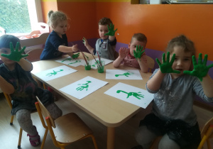 Przedszkolaki pokazują dłonie pomalowane farbą